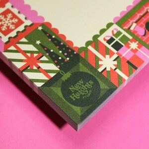 Peut inclure: Une pile de papeterie avec un motif de No&euml;l festif. La bordure pr&eacute;sente des bo&icirc;tes cadeaux, des sapins de No&euml;l et des flocons de neige en rouge, vert et rose. Le coin inf&eacute;rieur affiche une d&eacute;coration verte avec le texte "New Heights Studio".