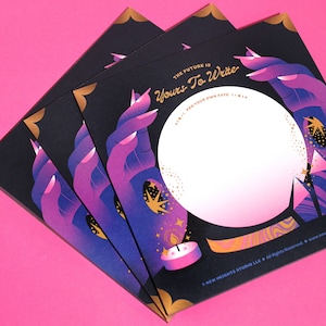 May include: A stack of four black cards with gold accents. The cards feature a purple hand holding a crystal ball with a white interior. The text on the card reads "The future is Yours To Write (+) Pen your own fate (+)".