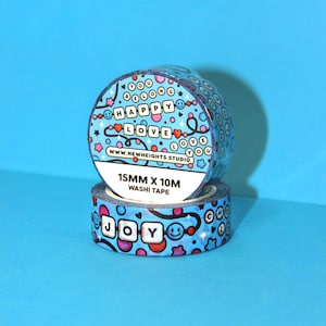 May include: Two rolls of blue washi tape with a colorful pattern of hearts, stars, and smiley faces. The tape features the words "You Belong Happy Love" and "Joy" in a blocky font. The tape is 15mm wide and 10m long.