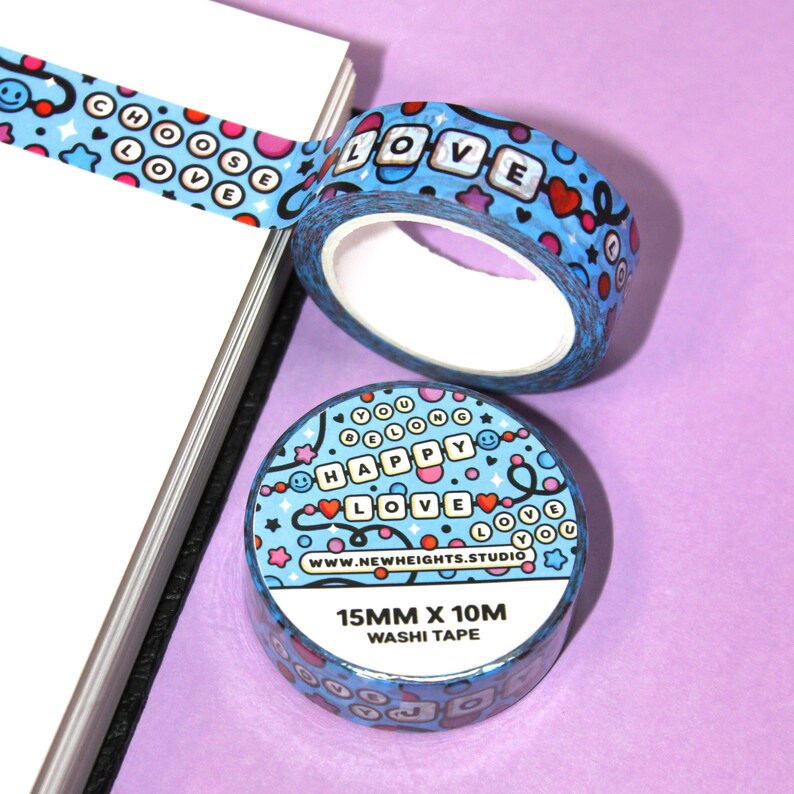 May include: Two rolls of blue and white washi tape with colorful designs. The tape features the words "Choose Love", "Love", "You Belong", "Happy", and "Love You". The tape is 15mm wide and 10m long.