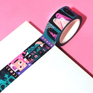 May include: A roll of washi tape with a Halloween theme. The tape features a black background with colorful illustrations of a haunted house, ghosts, a graveyard, and a crescent moon.
