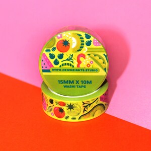 May include: Two rolls of yellow washi tape with a colorful fruit and vegetable design. The tape is 15mm wide and 10m long. The text on the tape reads "www.newheights.studio" and "15mm x 10m washi tape".