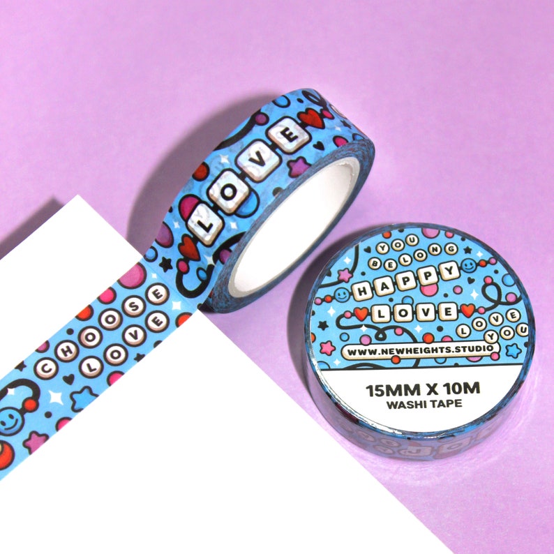 May include: Blue and pink washi tape with a repeating pattern of hearts, stars, smiley faces, and the words "Choose Love", "Happy", and "Love". The tape is 15mm wide and 10m long.