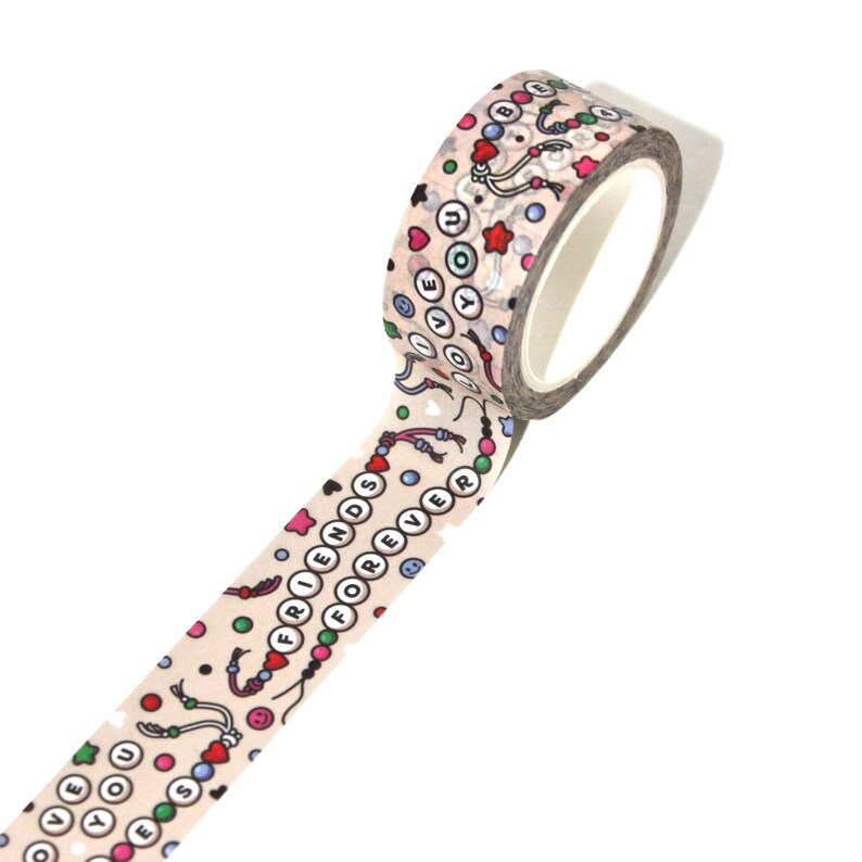 May include: A roll of washi tape with a beige background and a colorful pattern of beads, hearts, stars, and the words "Friends Forever" and "Love You".