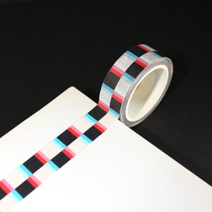 May include: A roll of washi tape with a black, white, red, and blue checkered pattern.