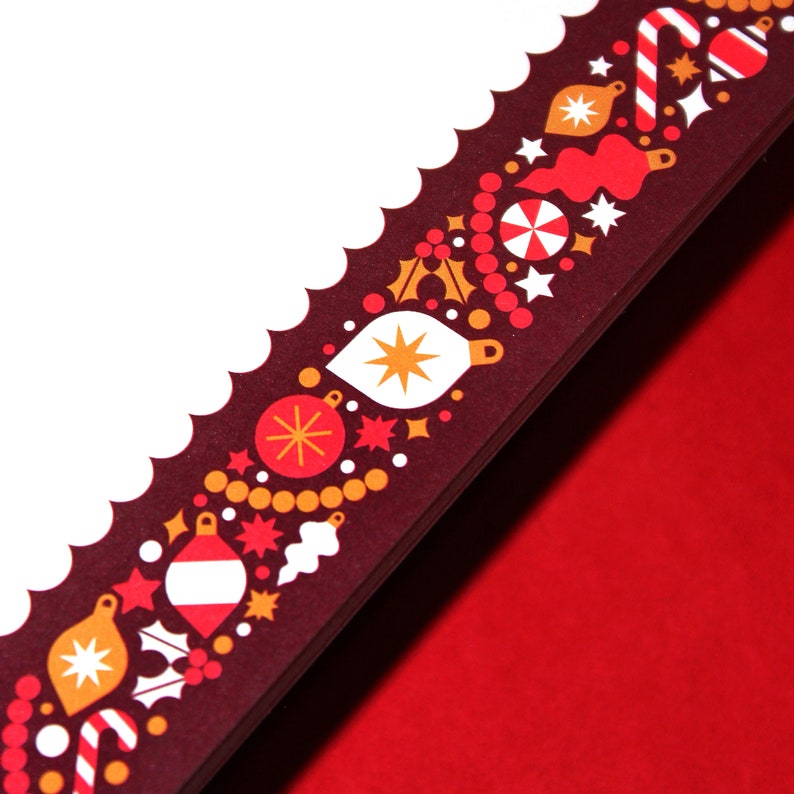 May include: A detail of a decorative border with a scalloped edge. The border is dark red with a repeating pattern of Christmas ornaments in white, orange, and red. The background is a solid red.