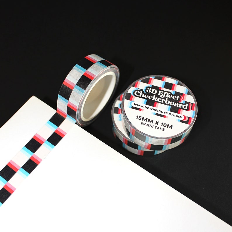 May include: A roll of black and white checkered washi tape with a red and blue 3D effect. The tape is 15mm wide and 10m long. The label on the tape reads "3D Effect Checkerboard" and "www.newheights.studio".