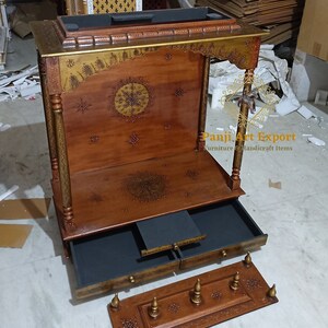 Handcrafted Wooden Prayer Temple with luxury carved design, traditional Indian architecture, decorative wooden pillars and functional storage drawer for pooja essentials. Beautiful home mandir for Lakshmi, Ganesha, Krishna and Bal Gopal idols. #PrayerRoomDecor #WoodenTemple #TempleFurniture #IndianHandicrafts #SpiritualDecor #TempleInterior #LuxuryTemple #HomeDecor #WoodCraft #EtsyFinds