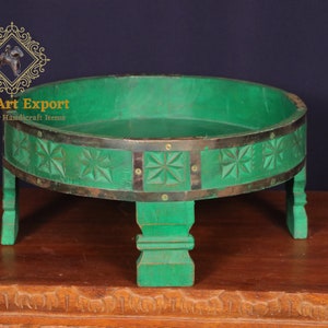 May include: A round wooden tray with a green painted finish and carved star designs. The tray sits on four short legs and has a brass band around the top edge.