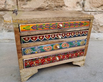Könnte beinhalten: Eine Holzkiste mit vier Schubladen, die jeweils mit bunten Mustern und Designs bemalt sind. Die Kiste hat silberne Knöpfe und ist in verschiedenen Farben dekoriert, darunter Rot, Blau, Grün, Gelb und Orange.
