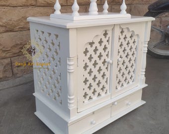 May include: White wooden temple with intricate latticework doors and two drawers. The temple has a decorative top with five finials.