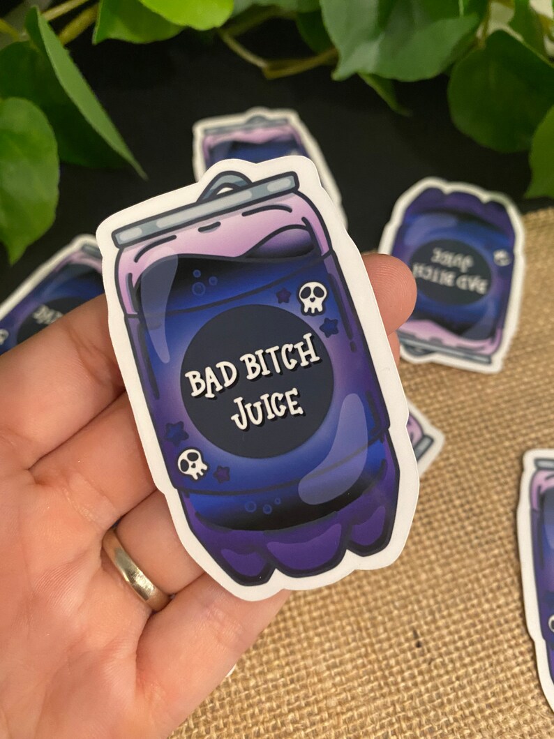 May include: A sticker of a purple and black can with the text "Bad Bitch Juice" and a skull graphic.