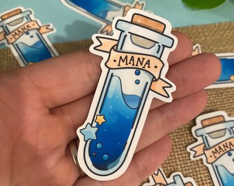 May include: A blue and white sticker of a glass test tube with a cork stopper. The test tube is filled with a blue liquid and has a white label that says "MANA". There are three small white stars and two small blue circles on the test tube.