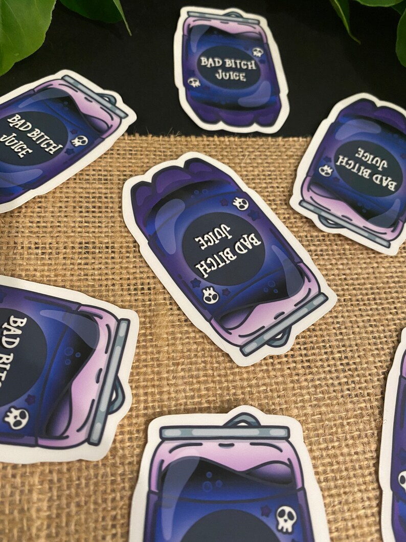 May include: A set of six stickers featuring a purple and black can with the text "Bad Bitch Juice" and a skull graphic. The stickers are on a burlap background.