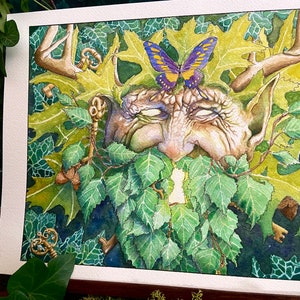May include: Watercolor painting of a green man's face with a butterfly on his forehead. The face is surrounded by leaves and branches, and there are keys and acorns scattered around.