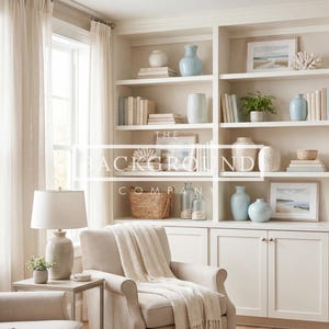 May include: A bright, airy living room with built-in white shelving. The shelves are decorated with books, vases, framed art, and decorative baskets. A beige armchair with a blanket and a matching sofa are in the foreground. The text "THE BACKGROUND COMPANY" is visible.