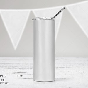 May include: A tall, cylindrical white tumbler with a smooth finish, featuring a clear plastic lid and a thin, straight metal straw inserted through the top opening. The vessel has a flat base and straight sides, designed for holding beverages.