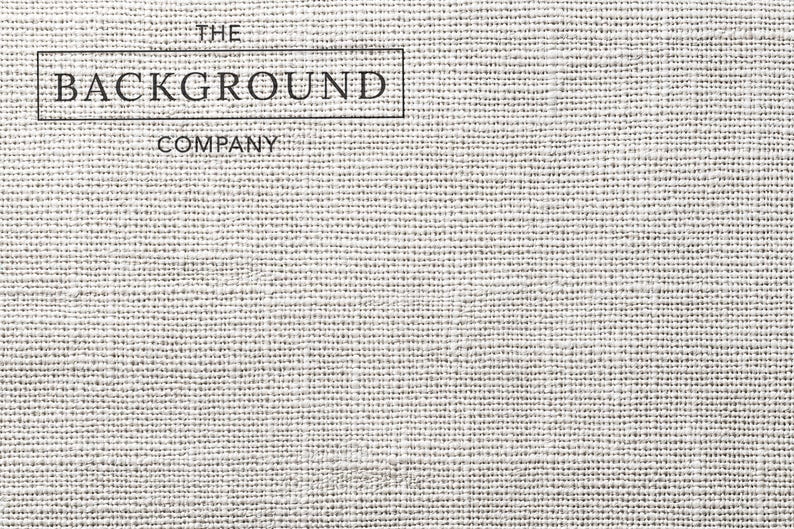 May include: A light gray, textured fabric surface with a visible woven pattern. In the upper left corner, there is a black rectangular border containing the text THE BACKGROUND COMPANY in a clean, sans-serif font, with the word COMPANY below it.