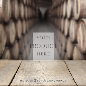 May include: A rustic wooden table surface in the foreground with a blurred background of stacked wooden barrels in a cellar. A central rectangular overlay contains the text YOUR PRODUCT HERE, and the bottom text reads INCLUDES 3 BONUS BACKGROUNDS.