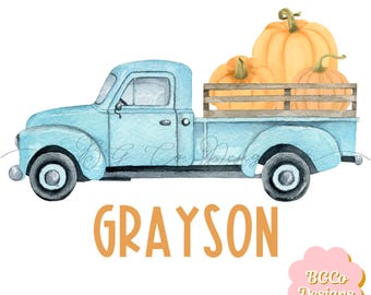May include: A light blue pickup truck with a wooden bed carrying three orange pumpkins. The truck has a black bumper and black wheels. The text "GRAYSON" is written in orange below the truck.
