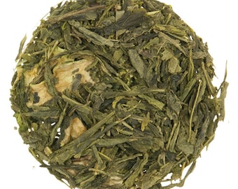 May include: A close-up of a pile of loose leaf green tea with pieces of dried fruit.