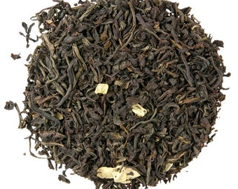 May include: A close-up of a pile of loose leaf black tea with small pieces of dried fruit or flower petals.