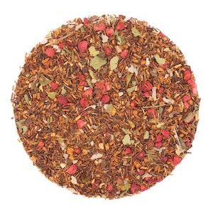 May include: A close-up of a blend of loose leaf tea with red fruit pieces, herbs, and wood chips.