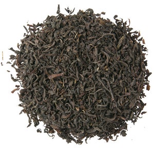 May include: Loose black tea leaves, dried and ready for brewing. The tea leaves are dark brown and have a slightly curled shape.