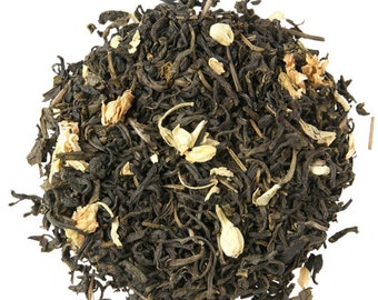 May include: A close-up of a pile of loose leaf green tea with white jasmine blossoms.