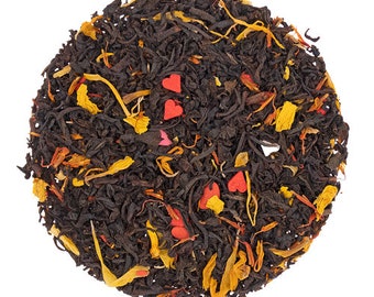 May include: A close-up of a blend of black tea leaves with orange and yellow flower petals and red heart-shaped sprinkles.