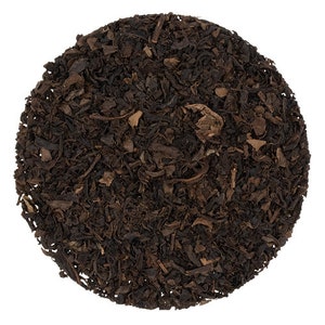 Könnte beinhalten: Lose schwarze Teeblätter, eine Mischung aus schwarzem Tee und getrockneten Fruchtstücken, zum Aufbrühen einer Tasse Tee.