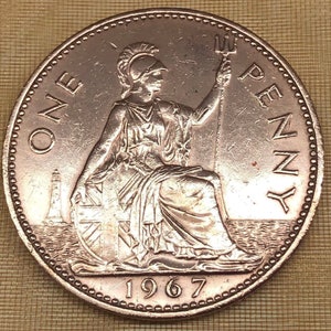 May include: A copper-colored British one penny coin with the year 1967 and the words "ONE PENNY" around the edge. The coin features a seated figure of Britannia holding a trident.