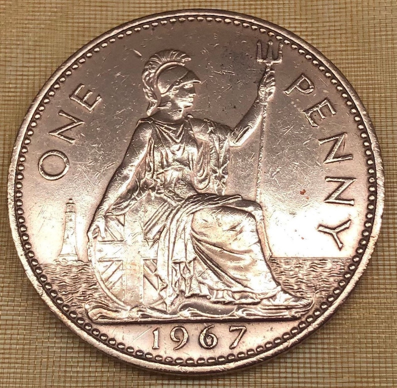 May include: A copper-colored British one penny coin with the year 1967 and the words "ONE PENNY" around the edge. The coin features a seated figure of Britannia holding a trident.