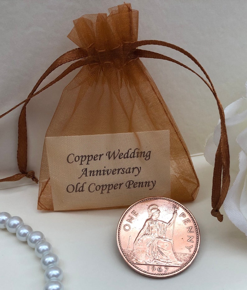 May include: A brown organza bag with a white card that reads "Copper Wedding Anniversary Old Copper Penny". A copper penny from 1967 is visible in the bag.