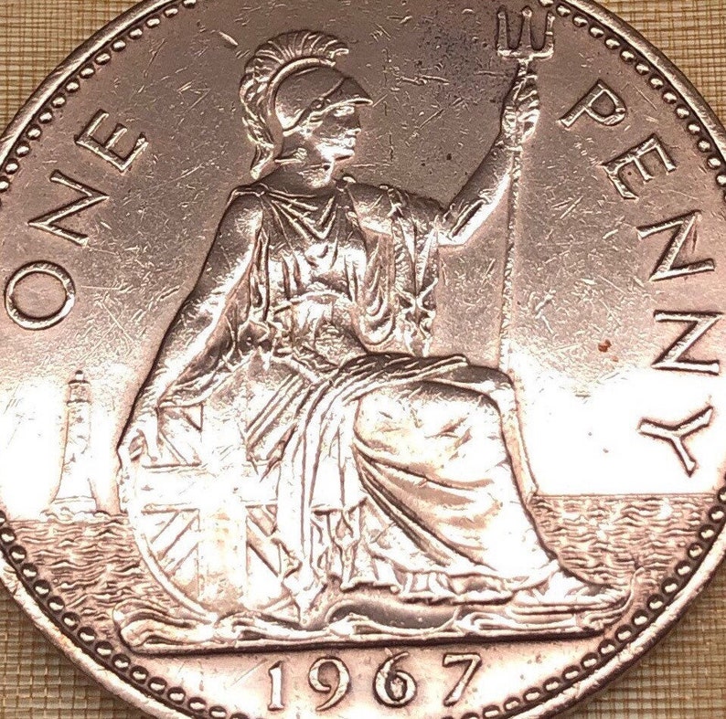 May include: A copper-colored British one penny coin with the image of Britannia, a woman wearing a helmet and holding a trident, sitting on a rock with a lighthouse in the background. The coin also features the year 1967 and the words "ONE PENNY".