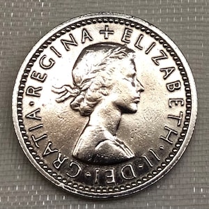 May include: Silver coin with a portrait of Queen Elizabeth II and the inscription "DEI. GRA.  REGINA  ELIZABETH II."