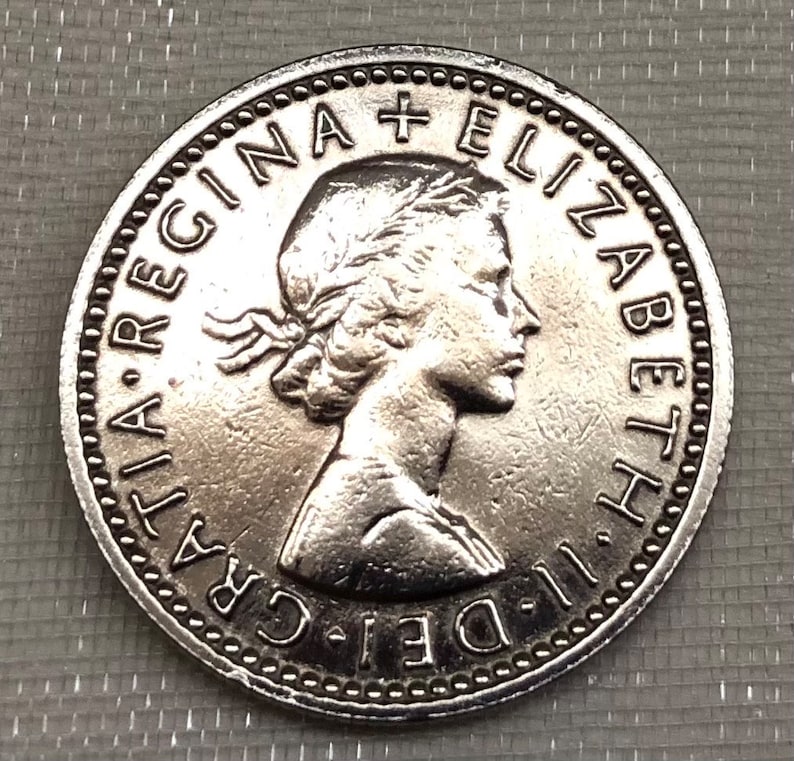 May include: Silver coin with a portrait of Queen Elizabeth II and the inscription "DEI. GRA.  REGINA  ELIZABETH II."