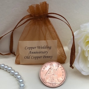May include: A small brown organza bag with a copper penny inside. The bag has a tag that reads "Copper Wedding Anniversary Old Copper Penny".