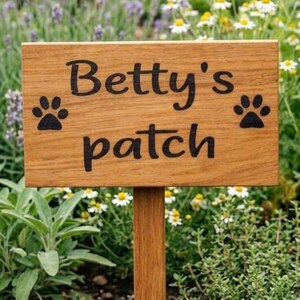 May include: A handmade wooden sign with the word "Welcome" in a whimsical font. The sign has a distressed white background and a dark brown border, suitable for a front door or hallway. The sign is roughly 30 cm wide and 15 cm tall.