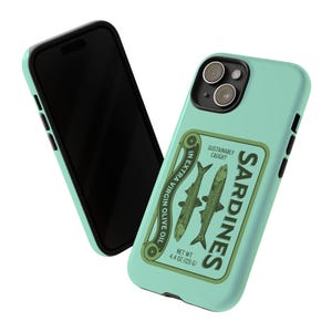 Peut inclure: Une coque de t&eacute;l&eacute;phone bleu turquoise avec un design de bo&icirc;te de conserve de sardines de style vintage. La bo&icirc;te pr&eacute;sente une &eacute;tiquette verte avec le texte "SARDINES" dans un encadr&eacute; blanc, "SUSTAINABLY CAUGHT" en texte plus petit, et deux sardines dans de l'huile d'olive extra vierge. Le poids net est indiqu&eacute; comme &eacute;tant de 125 g (4,4 oz).