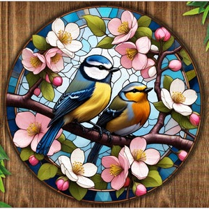 Könnte beinhalten: Ein rundes Design aus Buntglas mit zwei blauen Vögeln, die auf einem Zweig mit rosa und weißen Blüten sitzen. Die Vögel sind von einem bunten Buntglasdesign umgeben.