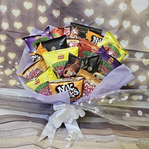 May include: A bouquet of various flavored potato chips, including Monster Munch, Nik Naks, and Golden Wonder, wrapped in clear cellophane and tied with a white ribbon.