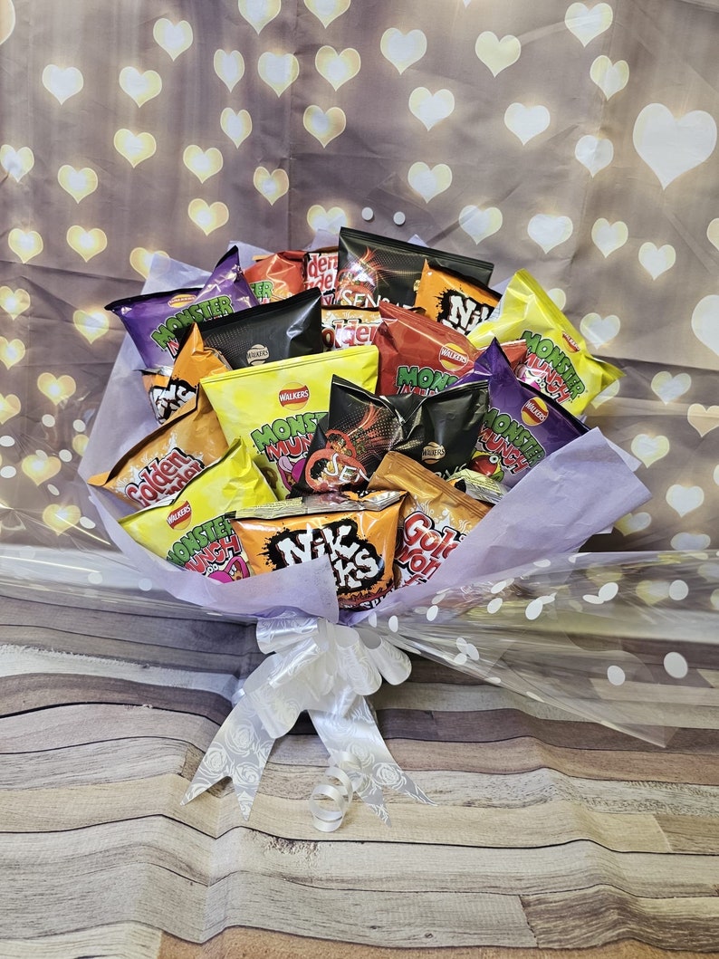 May include: A bouquet of various flavored potato chips, including Monster Munch, Nik Naks, and Golden Wonder, wrapped in clear cellophane and tied with a white ribbon.