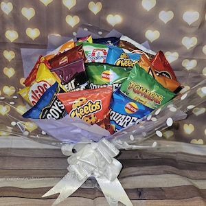 May include: A bouquet of various popular brands of potato chips, including Cheetos, Walkers, and Pombear, wrapped in clear cellophane with white polka dots and a white satin bow.