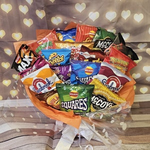 May include: A bouquet of various chip bags, including Seabrook, McCoy's, Monster Munch, Walkers Squares, and Walkers Cheese & Onion. The bouquet is wrapped in orange tissue paper and clear cellophane.