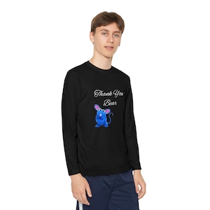 May include: Black long-sleeve shirt featuring a blue cartoon mouse with pink ears and a curly tail. The shirt has the text "Thank You Bear" in a script font above the mouse graphic. The shirt is made of a soft, comfortable material.