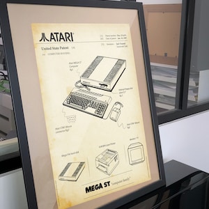 Puede incluir: Una ilustración de estilo vintage de la familia de computadoras Atari Mega ST. La ilustración incluye un diagrama de los componentes de la computadora, incluyendo la computadora en sí, un ratón, una unidad de disquete, un disco duro, una impresora láser y un monitor. La ilustración está en blanco y negro y tiene un fondo de papel amarillento. El texto "MEGA ST computer family" está en la parte inferior de la ilustración.