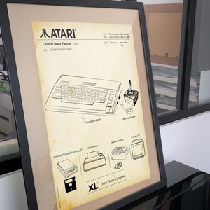 Op de afbeelding: Een zwart-witte lijntekening van de Atari XL 8-bits thuiscomputer. De tekening toont het ontwerp van de computer, inclusief het toetsenbord, de joystick en andere randapparatuur. De tekst "Atari XL 8-bits thuiscomputer" is onder de tekening afgedrukt.