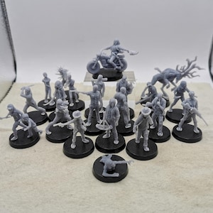 Peut inclure: Une collection de figurines en plastique gris représentant des personnages d'une série télévisée populaire. Les figurines sont posées dans diverses poses d'action et comprennent une moto, un cerf et diverses armes.