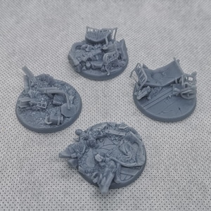 Könnte beinhalten: Vier graue 3D-gedruckte Miniatursockel mit verschiedenen Details aus Schutt und Trümmern. Die Sockel sind für Tabletop-Spiele konzipiert.